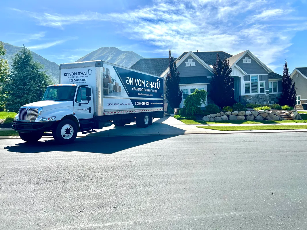 Utah's Moving & Storage branded moving truck parked in front of a Utah home with mountain views