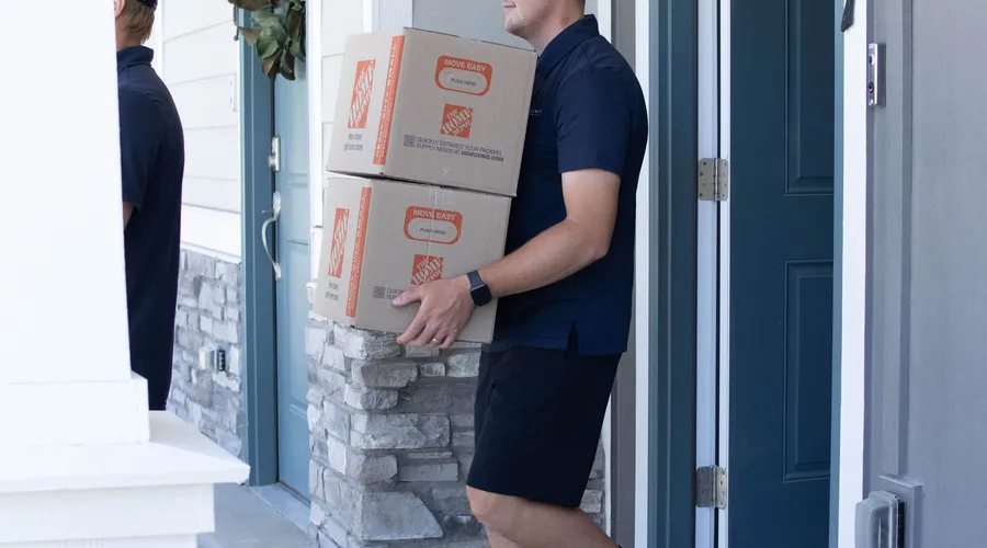 Mover carrying boxes into a Utah home