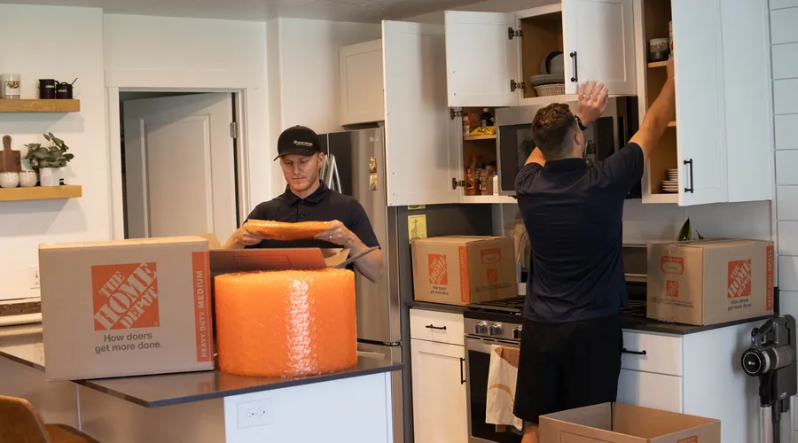 Crew professionally packing kitchen items with bubble wrap